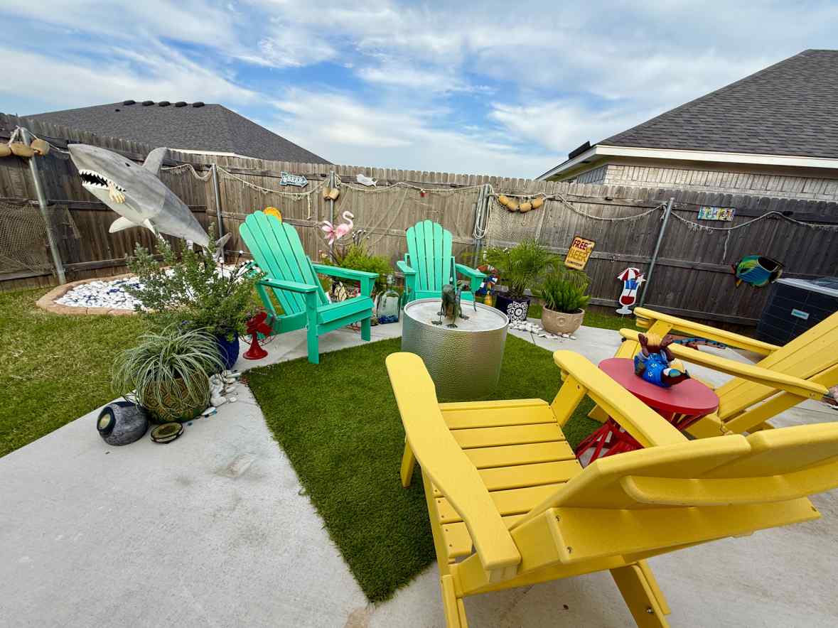 Yellow and teal Adirondack chairs arranged around the patio